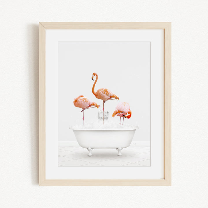 A framed image depicting three flamingos standing in a white bathtub filled with water.
