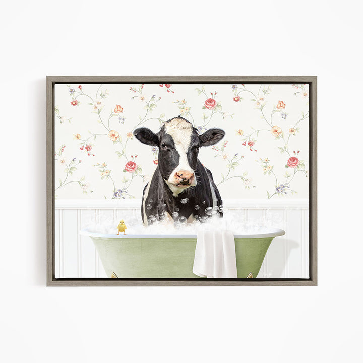 A black and white cow is sitting in a green bathtub filled with bubbles, with a yellow bird perched on the edge of the tub.