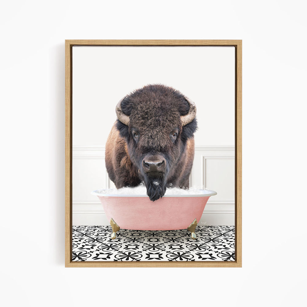 A buffalo with large horns is standing in a pink bathtub filled with water, creating a whimsical and humorous scene.