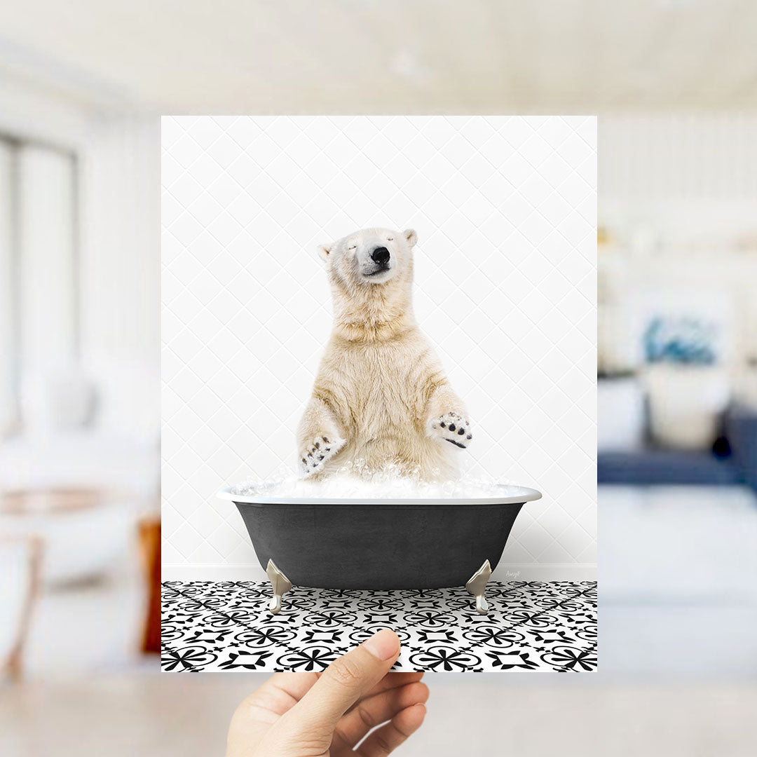 A polar bear standing in a bathtub filled with water, with a hand holding up the image to show it.