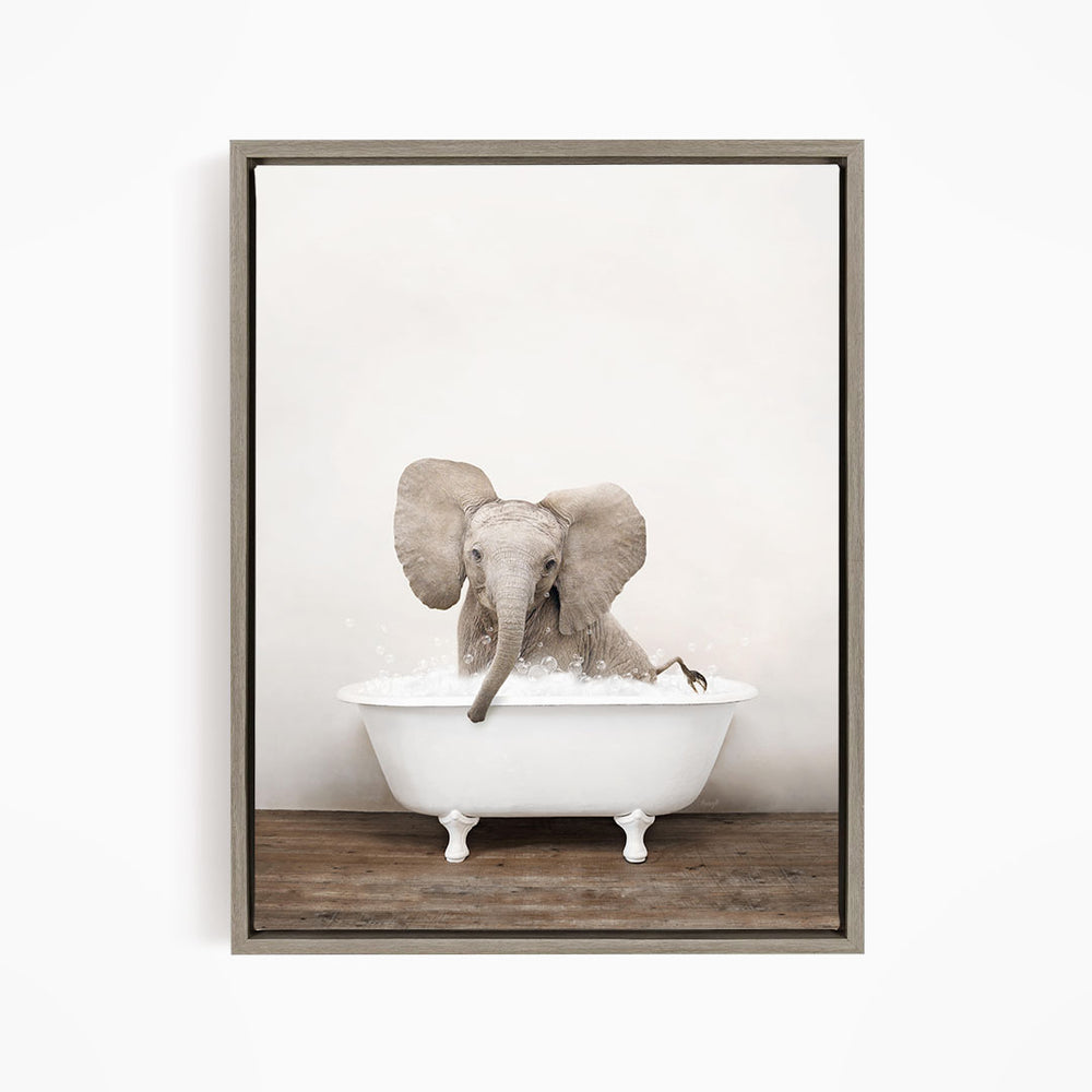 A baby elephant sitting in a white bathtub filled with water, with its trunk submerged in the water.