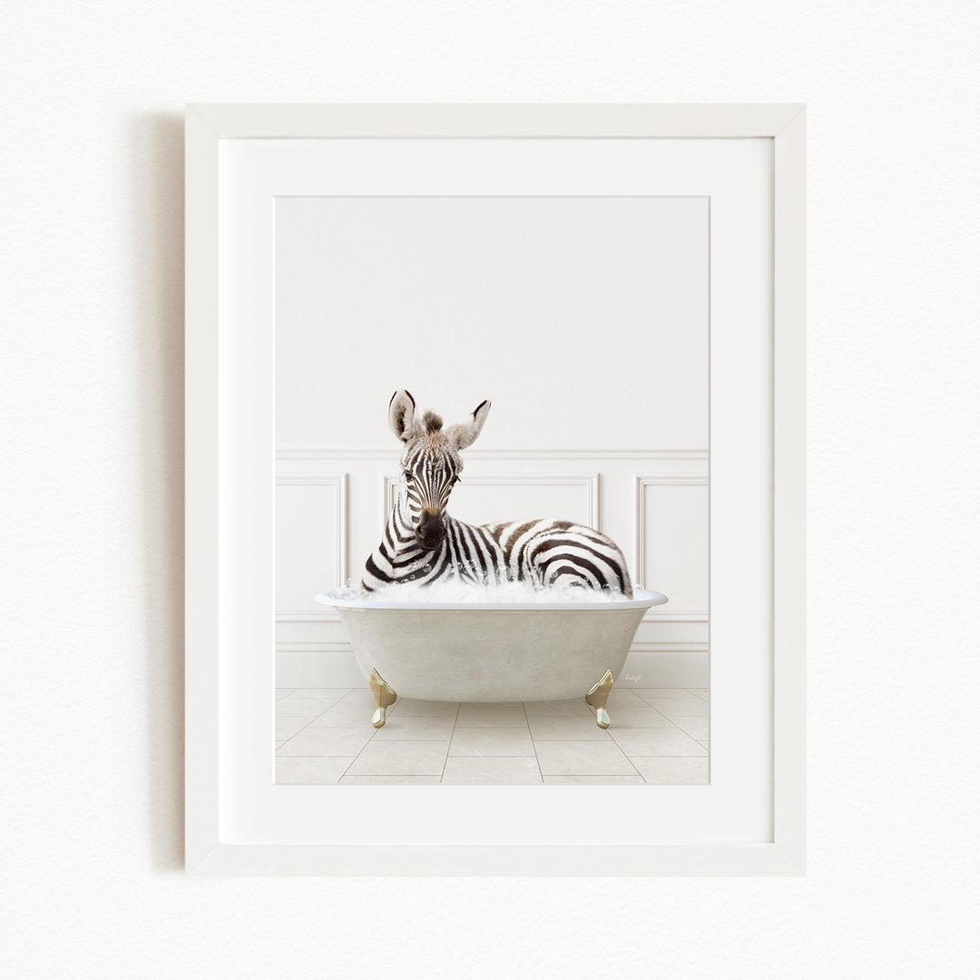 A zebra is sitting in a white bathtub, surrounded by a white wall and tiled floor.
