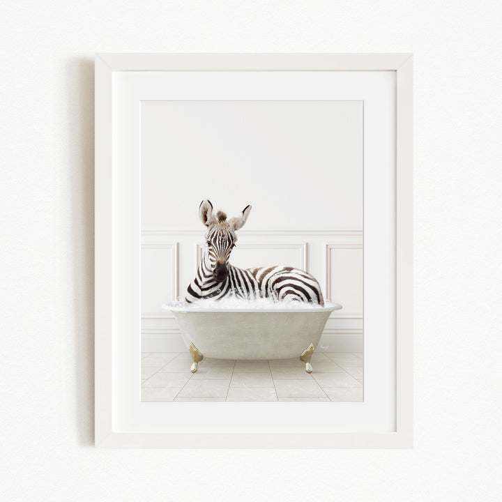 A zebra is sitting in a white bathtub, surrounded by a white wall and tiled floor.