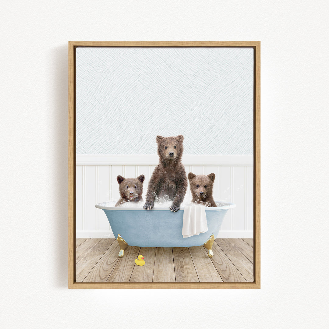 A framed image depicting three adorable brown bears sitting in a blue bathtub, with a yellow rubber duck floating in the water.