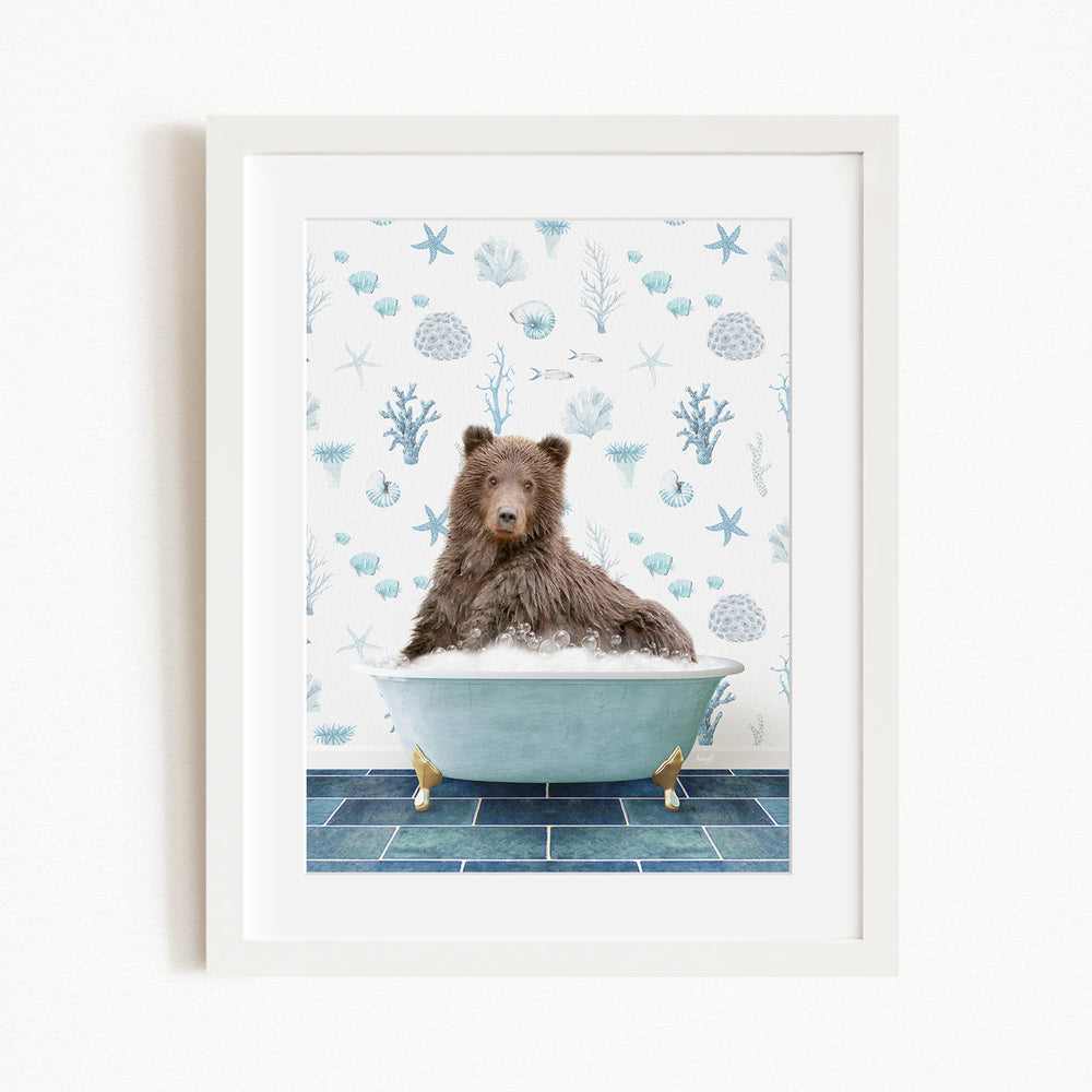 A brown bear sitting in a blue bathtub filled with bubbles, surrounded by a pattern of seashells and starfish on the wall behind it.