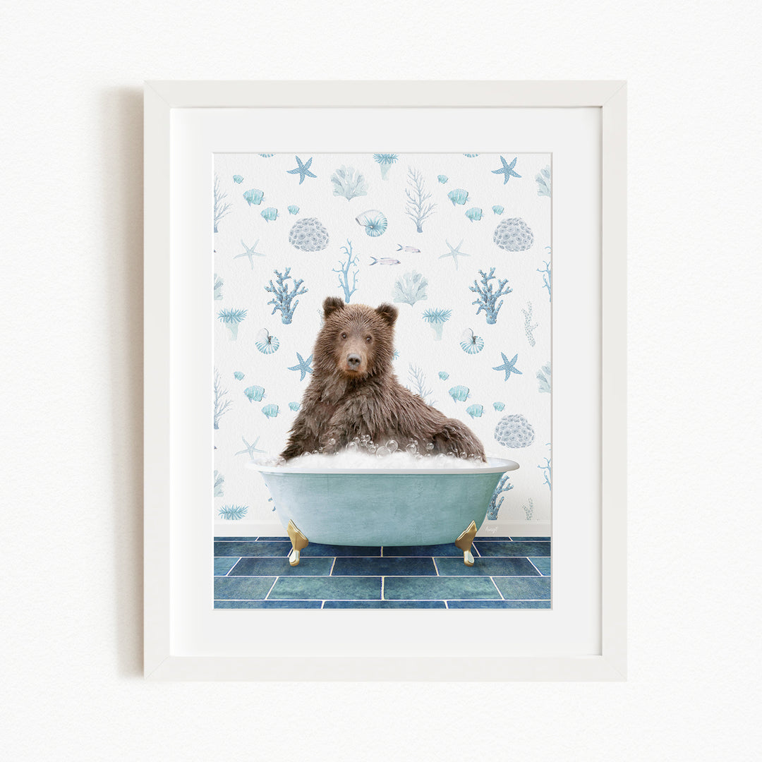 A brown bear sitting in a blue bathtub filled with bubbles, surrounded by a pattern of seashells and starfish on the wall behind it.