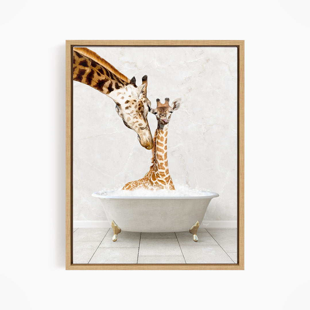 A mother giraffe and her baby giraffe are sitting together in a white bathtub, with the mother gently licking her baby.