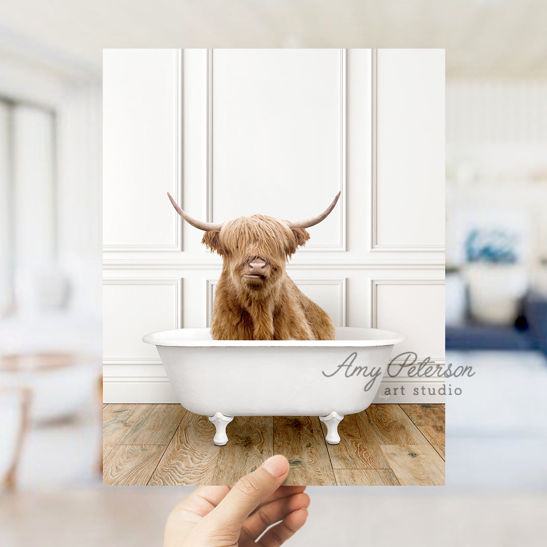 a hand holding up a photo of a dog in a bathtub