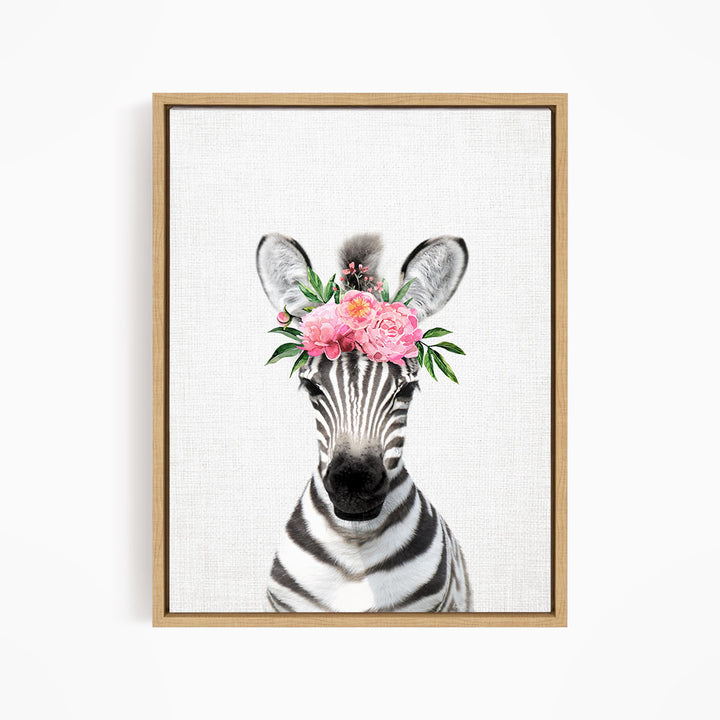 A zebra wearing a floral headpiece with pink flowers and green leaves.