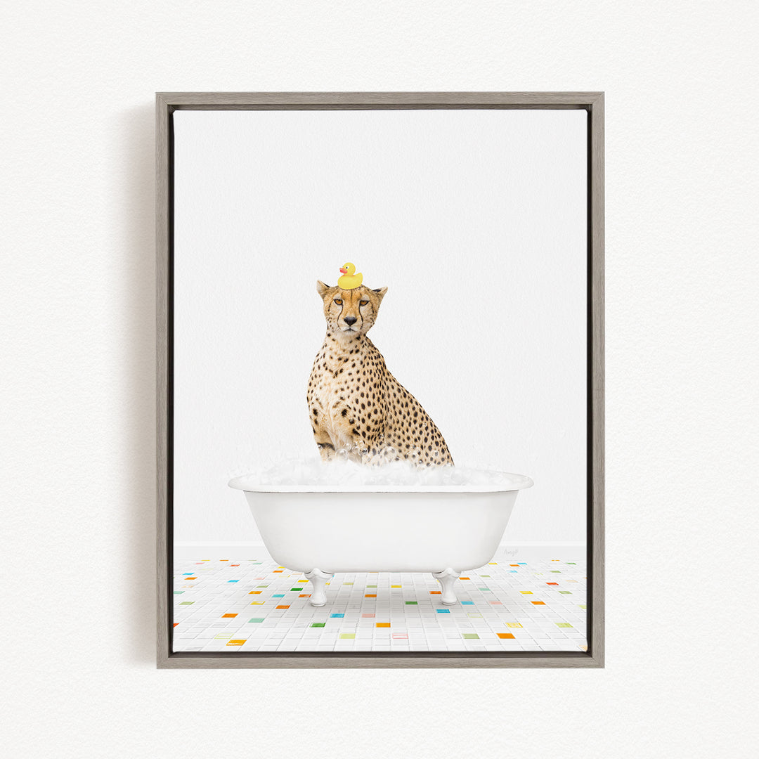 A cheetah sitting in a white bathtub filled with bubbles, wearing a yellow rubber duck hat.