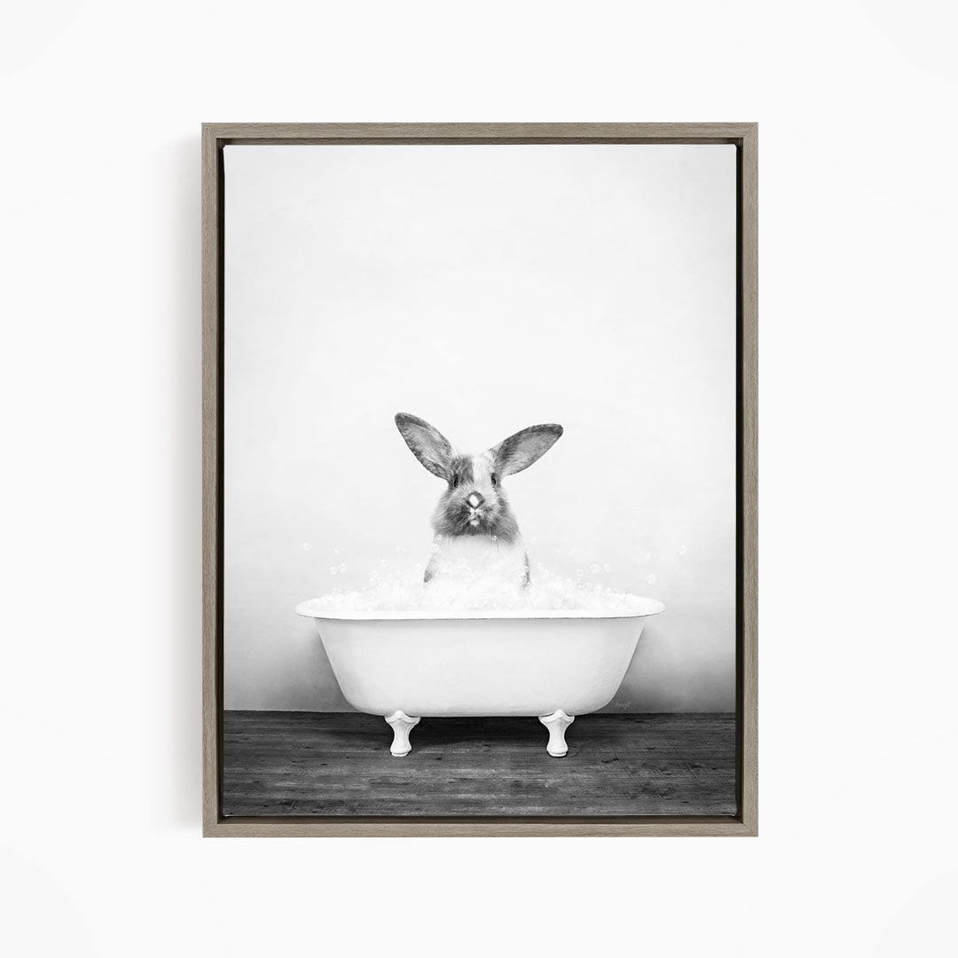 A rabbit sitting in a white bathtub filled with water, looking directly at the camera.