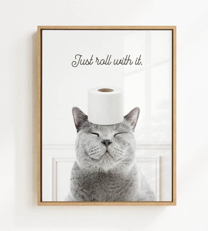 A gray cat with its eyes closed and a roll of toilet paper on its head, with the text "Just roll with it."