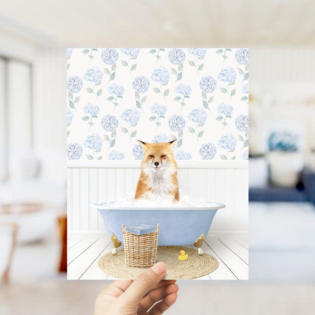 A fox is sitting in a blue bathtub filled with bubbles, surrounded by a floral patterned wall.