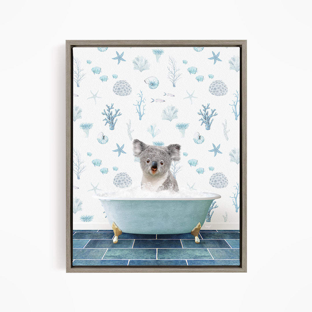 A koala bear sitting in a bathtub filled with bubbles, surrounded by a blue and white ocean-themed wallpaper.