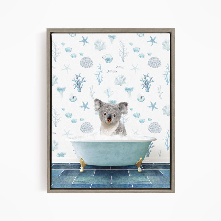 A koala bear sitting in a bathtub filled with bubbles, surrounded by a blue and white ocean-themed wallpaper.