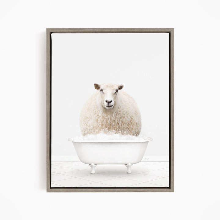 A fluffy white sheep sits in a white bathtub filled with bubbles, looking directly at the camera.