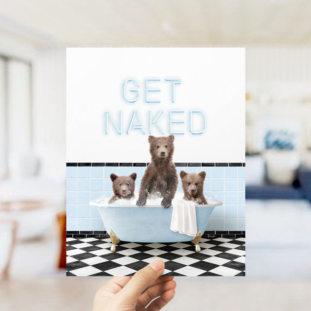 A hand holding a printed image of three bears sitting in a bathtub, with the text "GET NAKED" displayed above them.
