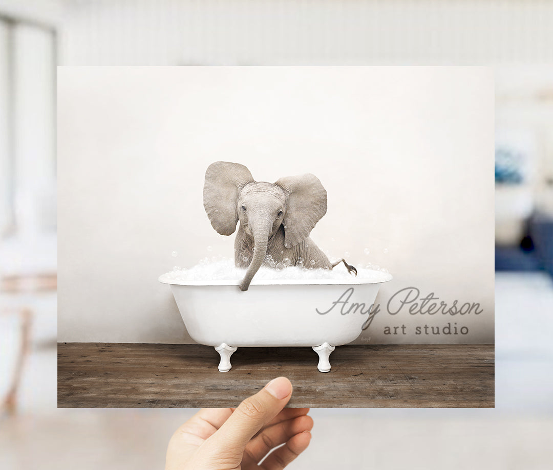 a person holding up a card with an elephant in a bathtub