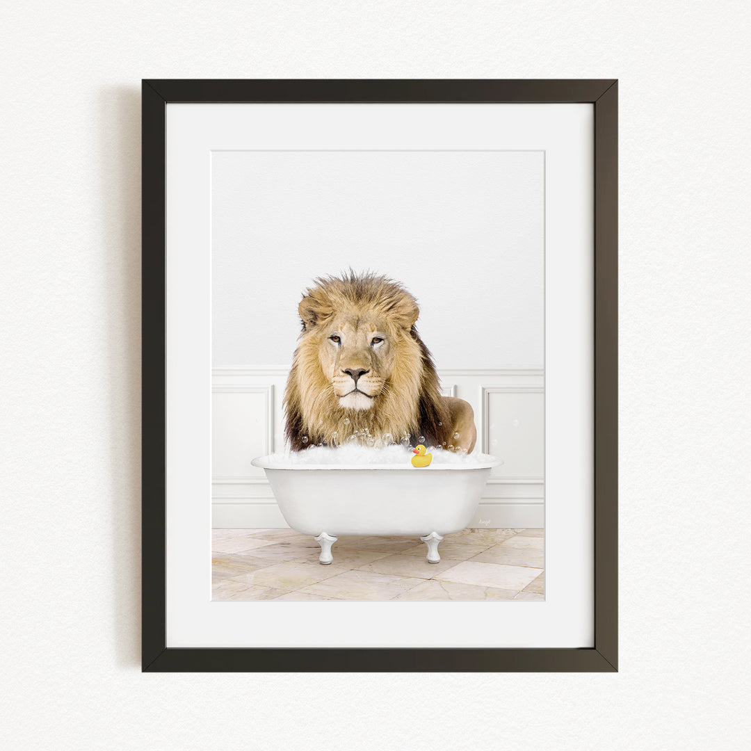 A lion sitting in a white bathtub filled with bubbles, with a yellow rubber duck floating in the water.