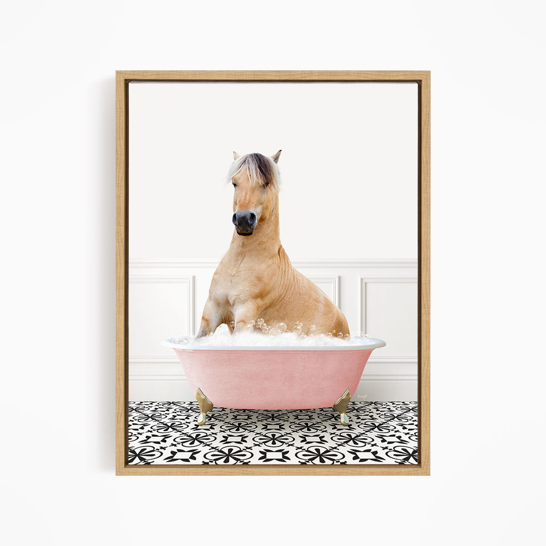 A light brown horse is sitting in a pink bathtub filled with water, surrounded by a black and white patterned floor.