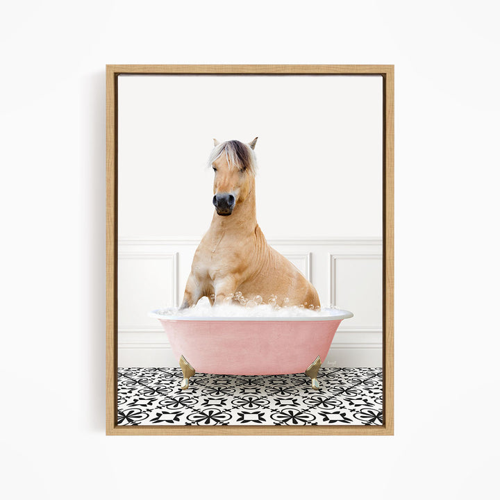 A light brown horse is sitting in a pink bathtub filled with water, surrounded by a black and white patterned floor.