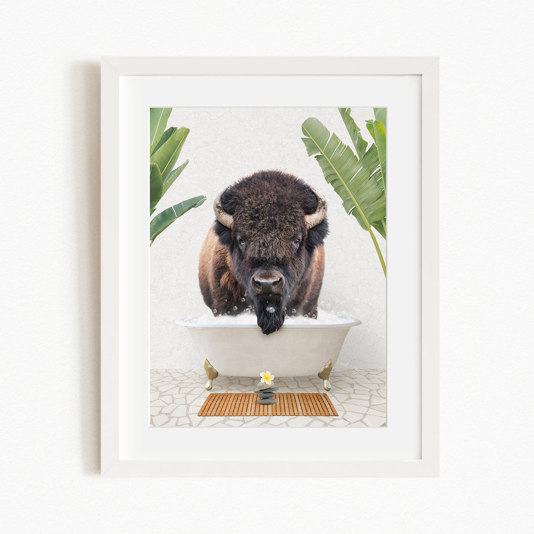 A buffalo is sitting in a bathtub filled with water, surrounded by tropical plants and a wooden mat on the floor.