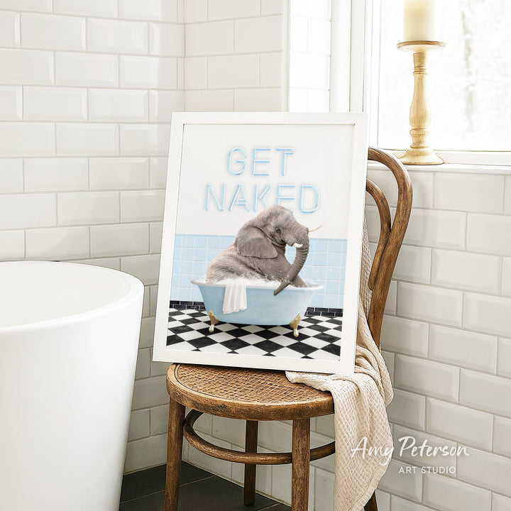 A framed image of a gray elephant sitting in a blue bathtub, with the text "GET NAKED" written on the frame.