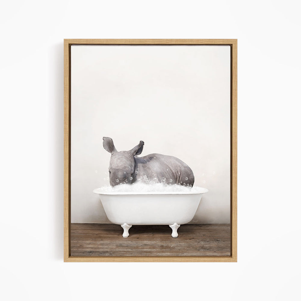 A rhinoceros is sitting in a white bathtub filled with water, creating a whimsical and playful scene.