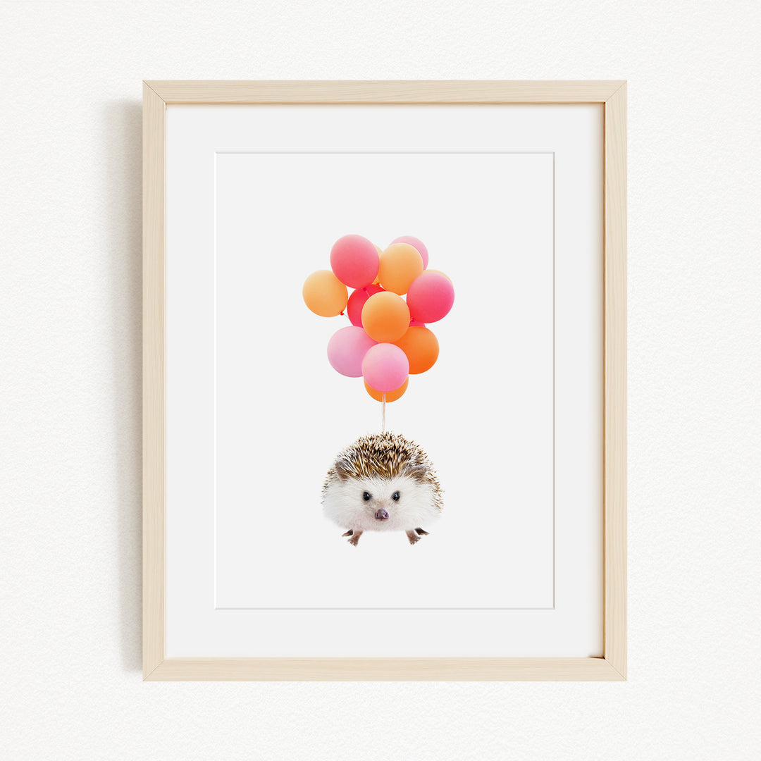 A framed print depicting a hedgehog floating in the air with a bunch of colorful balloons attached to it.