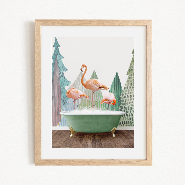 A framed image depicting three pink flamingos standing on a green bathtub, with a forest-like background.
