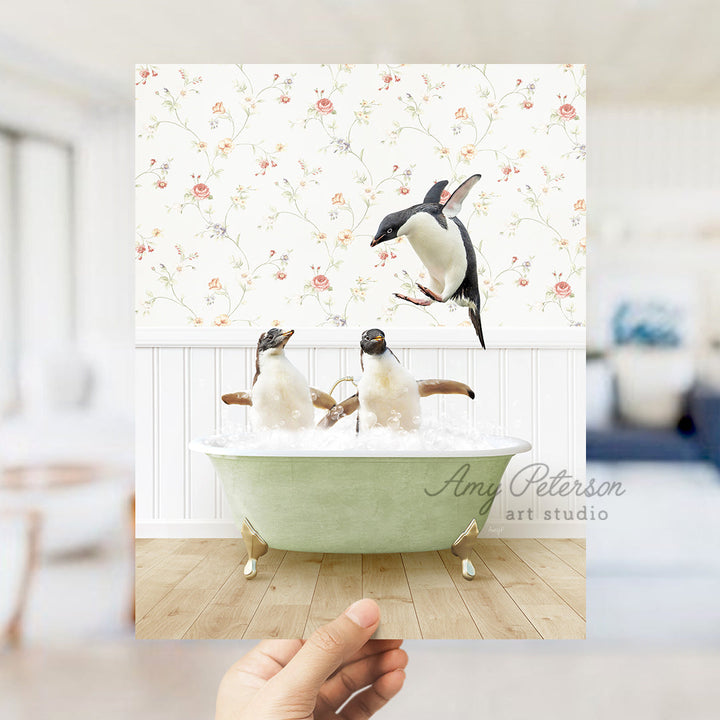 a hand holding up a card with penguins in a bathtub