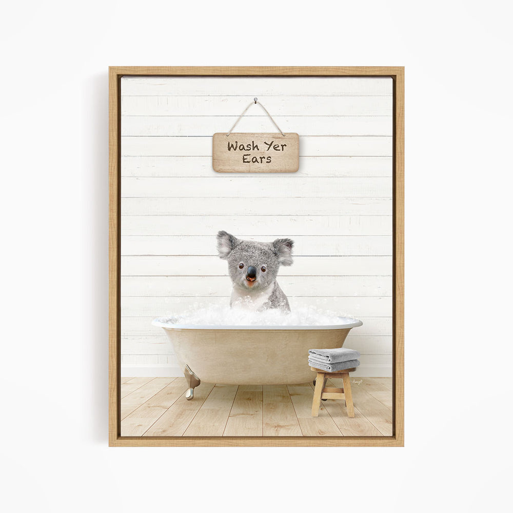 A koala bear sitting in a bathtub, with a sign above that says "Wash Your Ears".