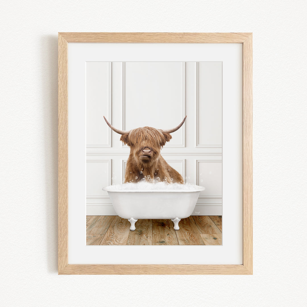 A brown Highland cow with long horns is sitting in a white bathtub filled with bubbles, creating a whimsical and amusing scene.