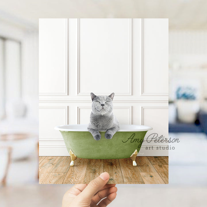 a hand holding a card with a cat sitting in a bathtub