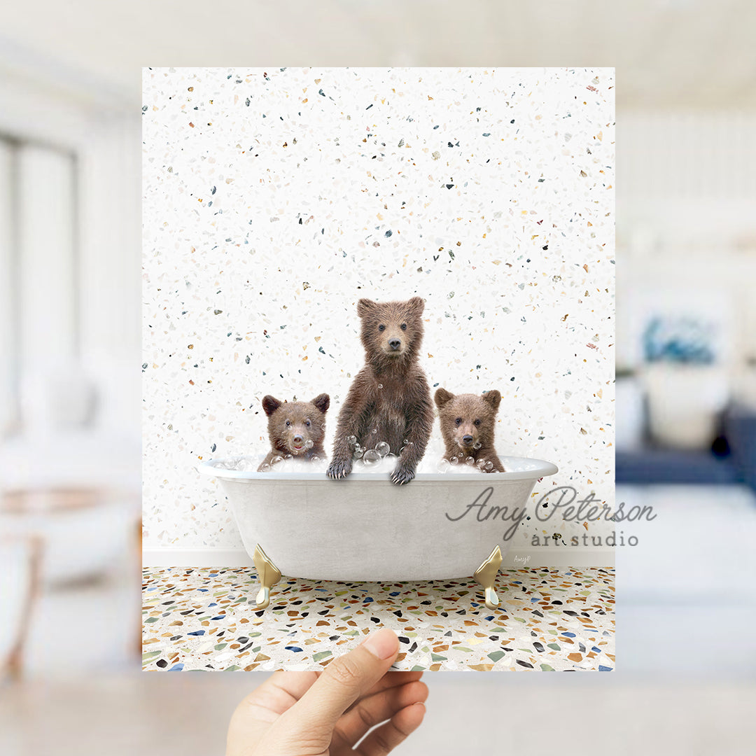 a hand holding a card with three bears in a bathtub