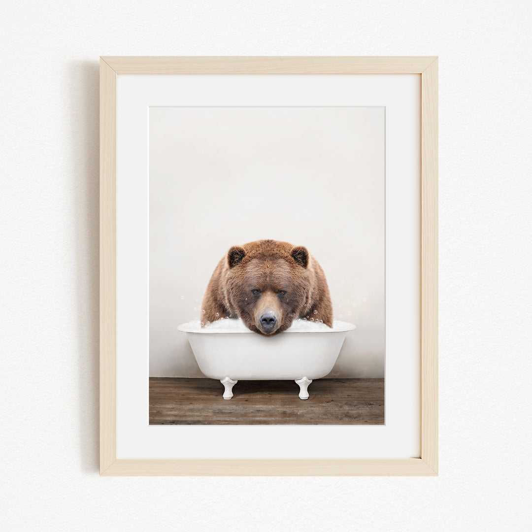 A brown bear is sitting in a white bathtub, appearing to be enjoying a relaxing bath.