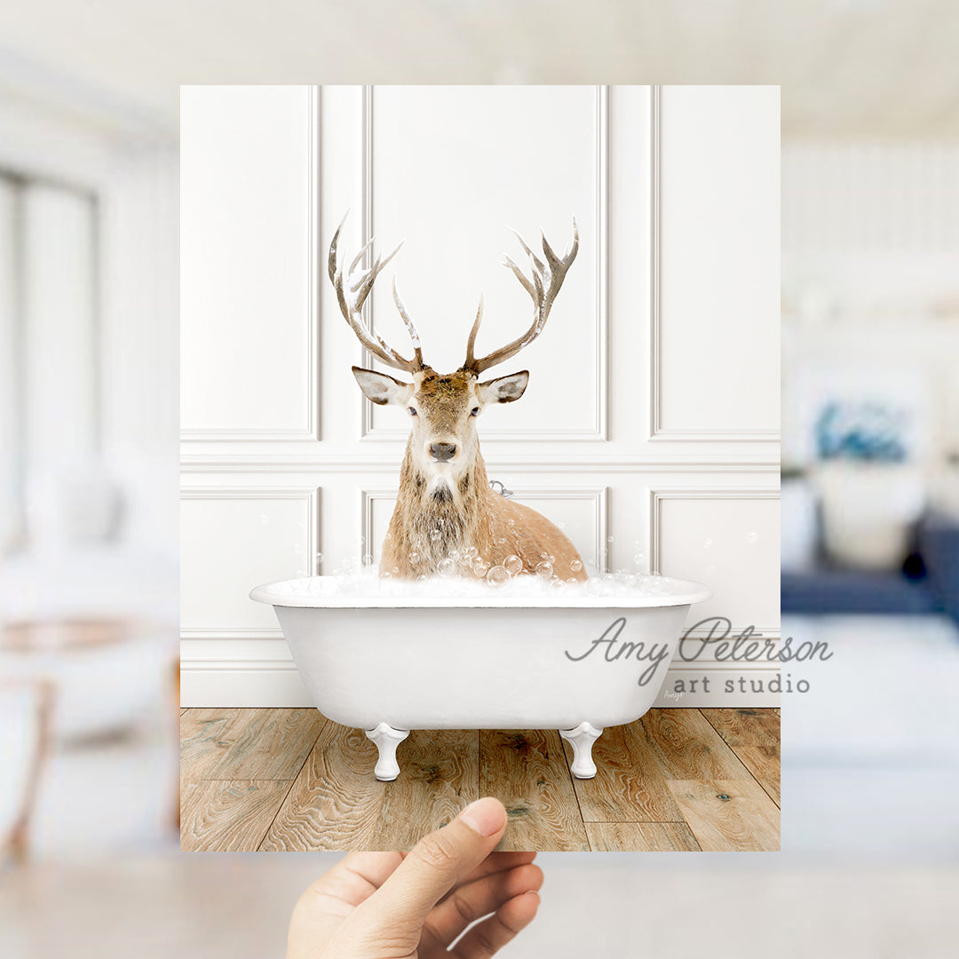 a hand holding a photo of a deer in a bathtub