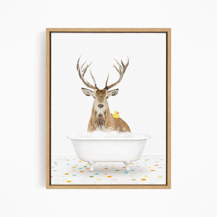 A deer with large antlers is sitting in a white bathtub filled with bubbles, with a yellow duck perched on its back.