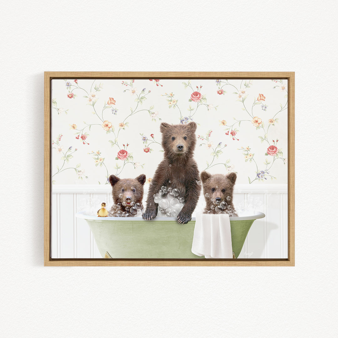 Three adorable brown bears sitting in a green bathtub, surrounded by a floral patterned wall.