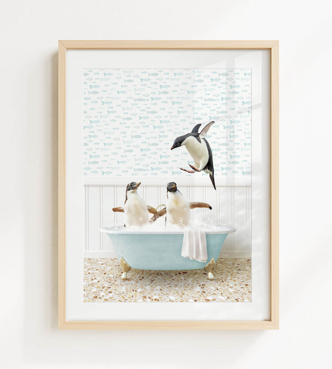 A framed image depicting two penguins sitting in a bathtub, with one penguin jumping out of the tub.