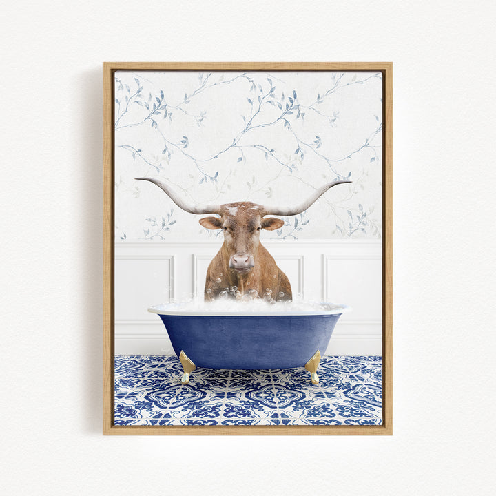 A brown bull with large horns is sitting in a blue bathtub filled with water, surrounded by a blue and white patterned rug.