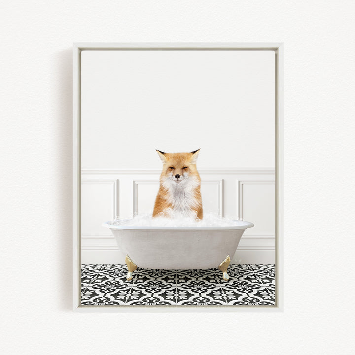 A red fox sitting in a white bathtub filled with bubbles, looking directly at the camera.
