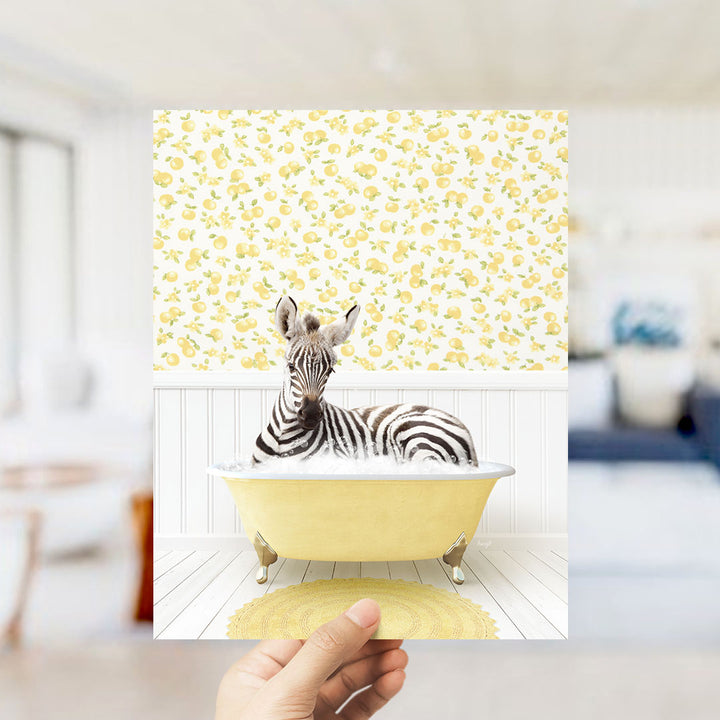 A zebra is sitting in a yellow bathtub, surrounded by a yellow and white floral pattern on the wall behind it.