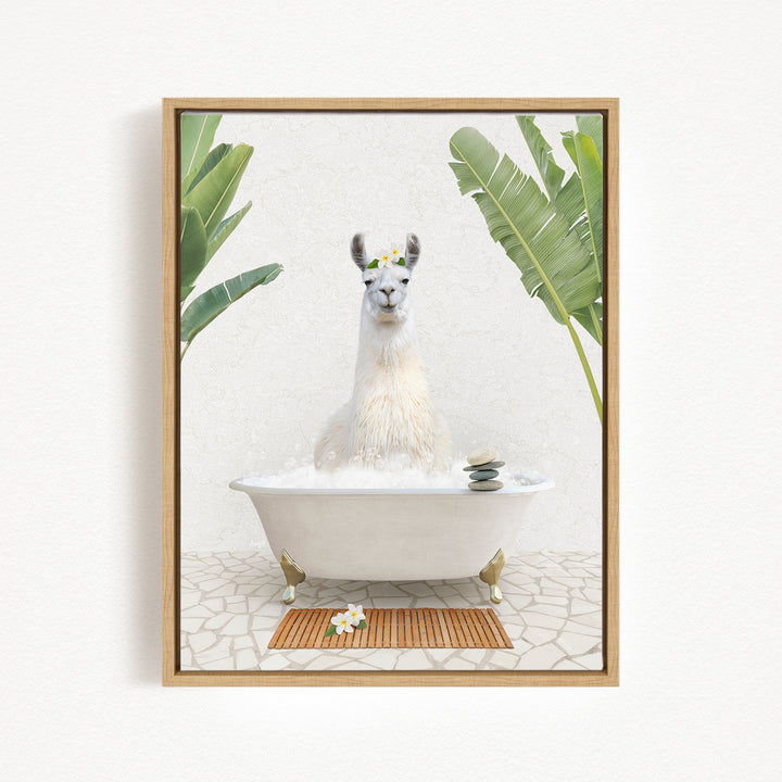 A white llama is sitting in a white bathtub filled with bubbles, surrounded by tropical plants and a wooden mat on the floor.