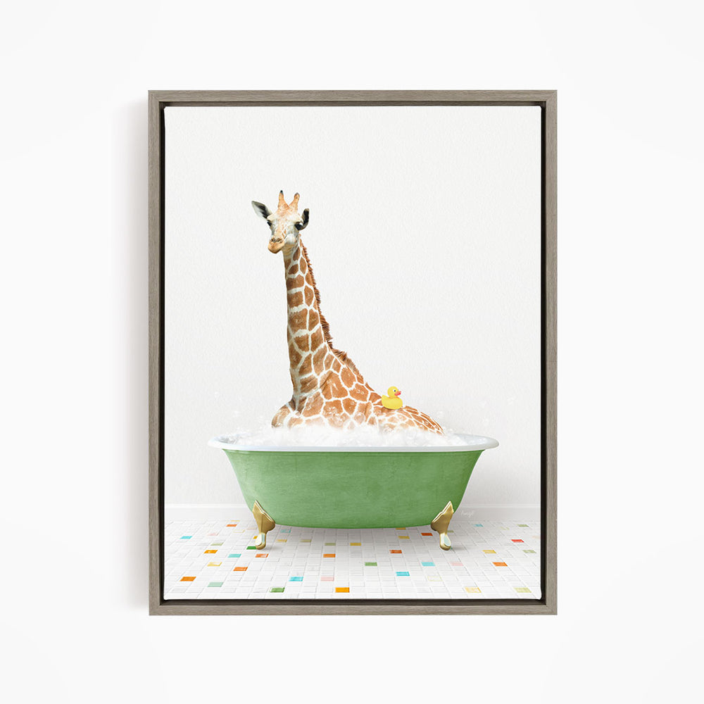 A giraffe is sitting in a green bathtub filled with bubbles, with a yellow rubber duck floating on the water.