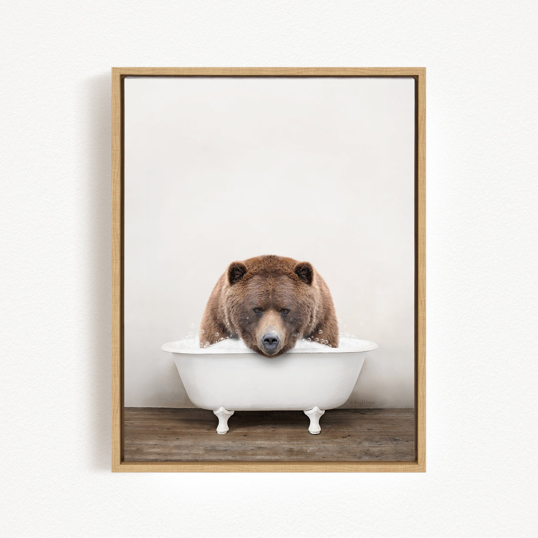 A brown bear is sitting in a white bathtub, appearing to be enjoying a relaxing bath.