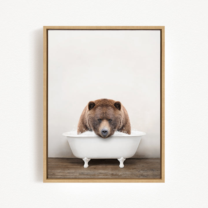 A brown bear is sitting in a white bathtub, appearing to be enjoying a relaxing bath.