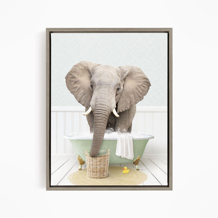 A gray elephant is standing in a green bathtub filled with water, surrounded by a yellow rubber duck and a basket.