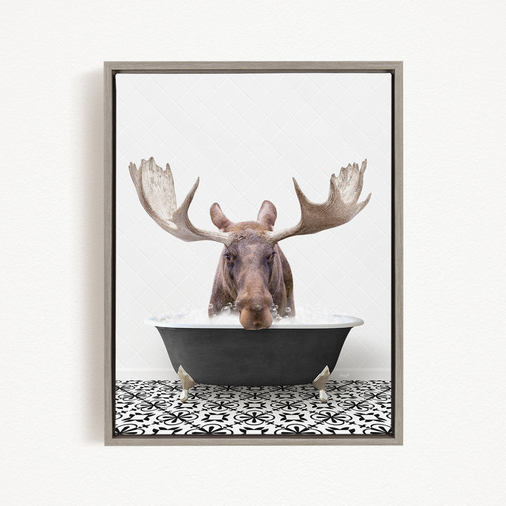A moose with large antlers is sitting in a bathtub filled with water, creating a whimsical and playful scene.