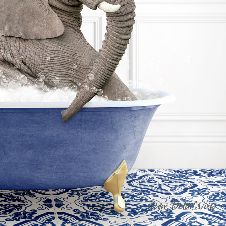 A large elephant is sitting in a blue bathtub filled with bubbles, with its trunk curled around the edge of the tub.